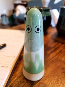 Image of a sculpture with eyes drawn on in marker.