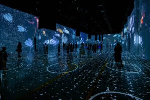 Photo of people in an art gallery with an experimental, digital design featuring insects.